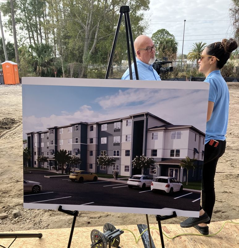 At a groundbreaking ceremony on Feb. 18, 2026, officials talk next to an image of what the Lakewood Senior Housing development will look like in Daytona Beach.