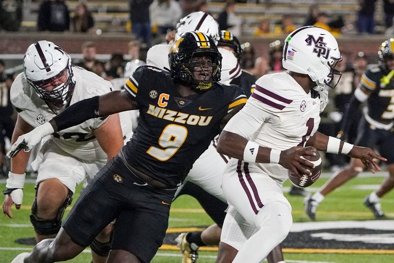 Nov 15, 2025; Columbia, Missouri, USA; Mississippi State Bulldogs quarterback Kamario Taylor (1) runs the ball as Missouri Tigers defensive end Zion Young (9) attempts the sack during the second half of the game at Faurot Field at Memorial Stadium. Mandatory Credit: Denny Medley-Imagn Images