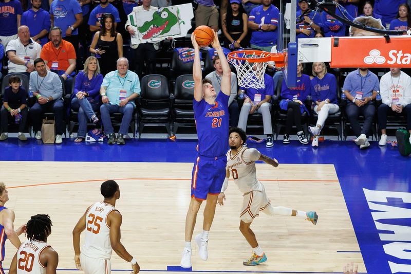 Jan 18, 2025; Gainesville, Florida, USA; Florida Gators forward Alex Condon (21) dunks the ball over Texas Longhorns guard Jordan Pope (0) during the second half at Exactech Arena at the Stephen C. O'Connell Center. Mandatory Credit: Matt Pendleton-Imagn Images