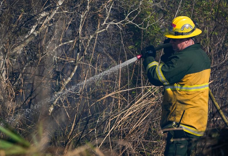 St. Lucie County Fire District crews and firefighters from the Florida Forest Service work to contain a brush fire near the 1700 block of Savannah Street in the Savannas Preserve State Park next to Indian River Estates near Fort Pierce on Feb. 25, 2026. The fire had grown to about 10 acres by 3:30 p.m. and firefighters had it about 30% contained, said fire officials. No homes had to be evacuated as of 3:30 p.m.