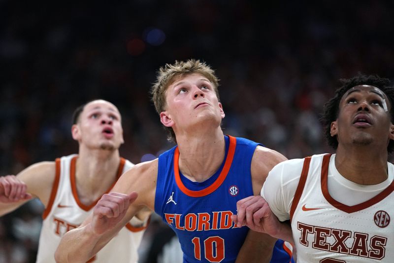 Feb 25, 2026; Austin, Texas, USA; Florida Gators forward Thomas Haugh (10) rebounds against Texas Longhorns guard Dailyn Swain (3) during the second half at Moody Center. Mandatory Credit: Dustin Safranek-Imagn Images