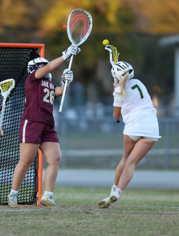 Forest Lauren Lemstrom (7) tries for the goal Oak Hall Savannah Loges (26) during an FHSAA girls lacrosse game at Forest High School in Ocala, FL on Monday, March 2, 2026. [Alan Youngblood/Gainesville Sun]