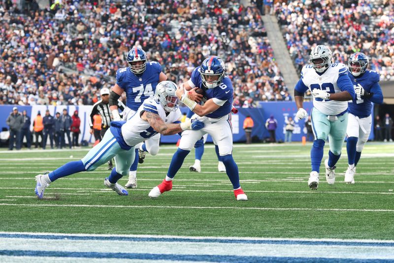 Jan 4, 2026; East Rutherford, New Jersey, USA; New York Giants quarterback Jaxson Dart (6) scrambles and is tackled by Dallas Cowboys linebacker Logan Wilson (55) during the second quarter at MetLife Stadium. Mandatory Credit: Vincent Carchietta-Imagn Images
