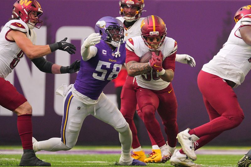 Dec 7, 2025; Minneapolis, Minnesota, USA; Washington Commanders running back Chris Rodriguez Jr. (36) rushes the ball against Minnesota Vikings linebacker Jonathan Greenard (58) during the first half at U.S. Bank Stadium. Mandatory Credit: Brad Rempel-Imagn Images