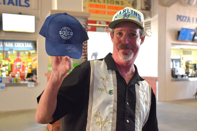 Ivan Nixon poses with his signed Kevin Youkilis hat during a World Baseball Classic exhibition game between Team Israel and the Miami Marlins on March 3, 2026.