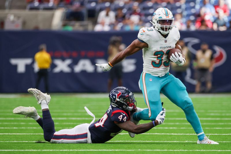 Aug 19, 2023; Houston, Texas, USA; Miami Dolphins running back Chris Brooks (33) breaks the tackle of Houston Texans cornerback Darius Phillips (44) in the fourth quarter at NRG Stadium. Mandatory Credit: Thomas Shea-USA TODAY Sports