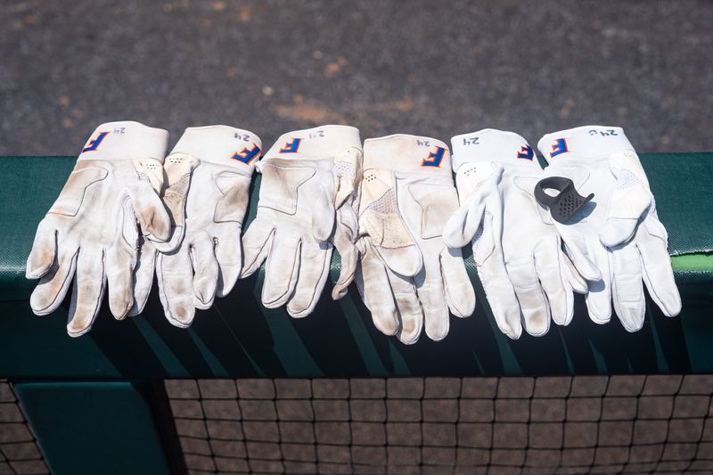 Jun 17, 2024; Omaha, NE, USA; Gloves for Florida Gators outfielder Blake Brookins (24) sit in the dugout before the game against the NC State Wolfpack at Charles Schwab Field Omaha. Mandatory Credit: Dylan Widger-USA TODAY Sports