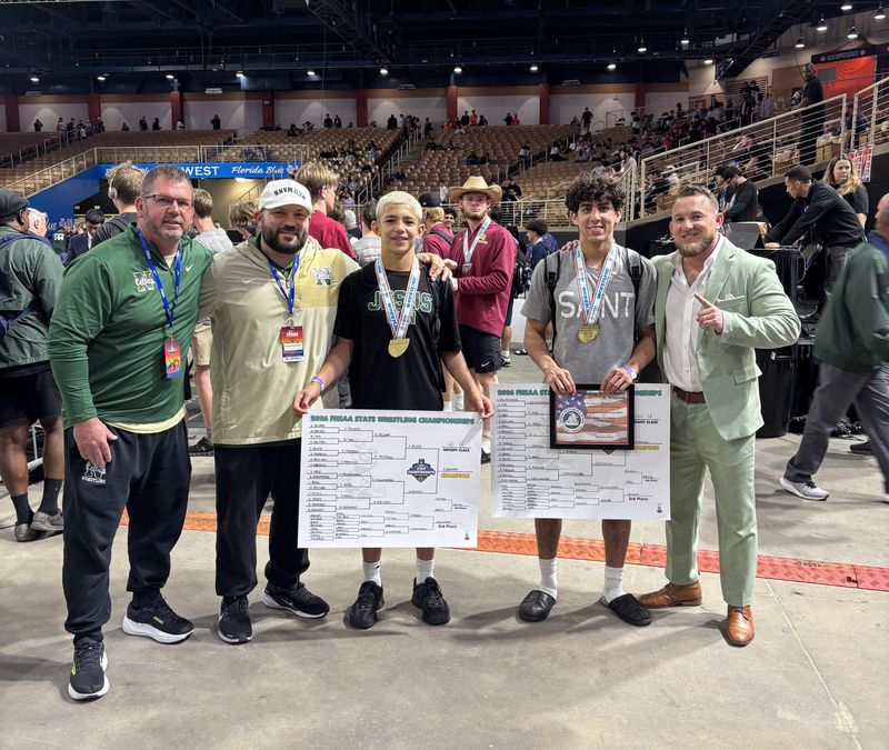 St. John Neumann state champion wrestlers Benito Barnhart and Lincoln Sledzianowski pose with the Celtics' coaching staff at the FHSAA State Championships in Kissimmee on March 7, 2026.