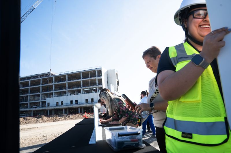 Shubhangi Purani, an employee of Skanska signs a picture at a ceremony for phase one of the new Lee Health’s Fort Myers Hospital on Monday, March 9, 2026.