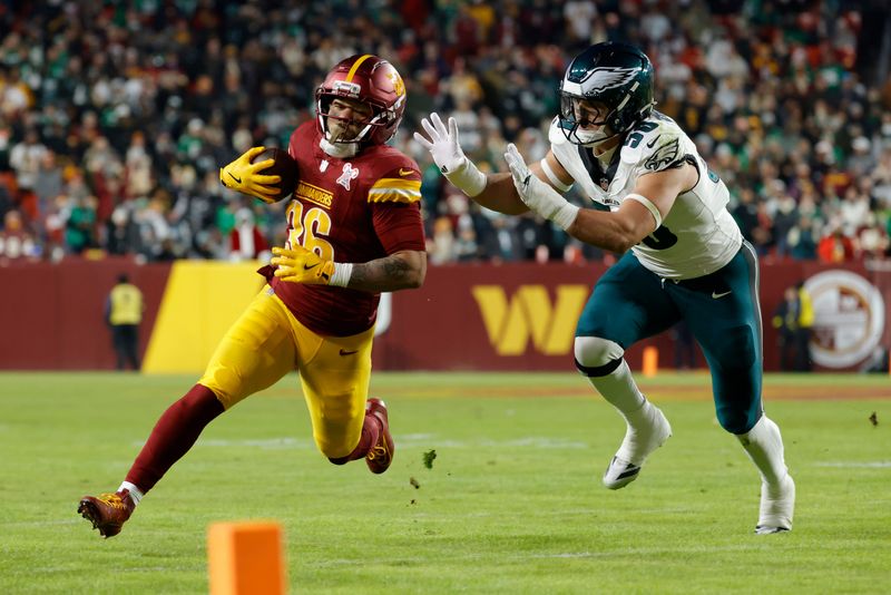 Dec 20, 2025; Landover, Maryland, USA; Washington Commanders running back Chris Rodriguez Jr. (36) runs against Philadelphia Eagles linebacker Jaelan Phillips (50) during the first half at Northwest Stadium. Mandatory Credit: Amber Searls-Imagn Images