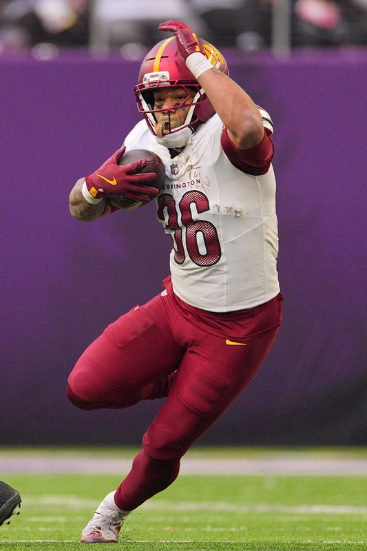 Dec 7, 2025; Minneapolis, Minnesota, USA; Washington Commanders running back Chris Rodriguez Jr. (36) rushes the ball against the Minnesota Vikings during the second half at U.S. Bank Stadium. Mandatory Credit: Brad Rempel-Imagn Images