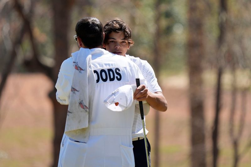 Mar 22, 2025; Graniteville, South Carolina, USA; Charlie Woods hugs his caddie after finishing No. 18 during the final round of the Junior Invitational at Sage Valley Golf Club. Mandatory Credit: Katie Goodale - Augusta Chronicle/USA TODAY NETWORK