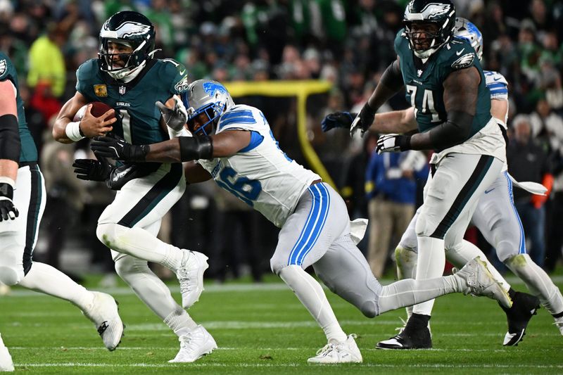 Nov 16, 2025; Philadelphia, Pennsylvania, USA; Philadelphia Eagles quarterback Jalen Hurts (1) rushes the ball against Detroit Lions linebacker Al-Quadin Muhammad (96) during the first half at Lincoln Financial Field. Mandatory Credit: Eric Hartline-Imagn Images