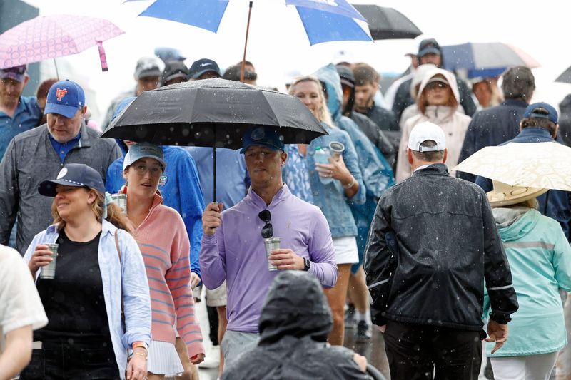 Mar 16, 2025; Ponte Vedra Beach, Florida, USA; Fans head to safety after play was temporarily suspended due to inclement weather during the final round of The Players Championship golf tournament at TPC Sawgrass. Mandatory Credit: Jeff Swinger-Imagn Images