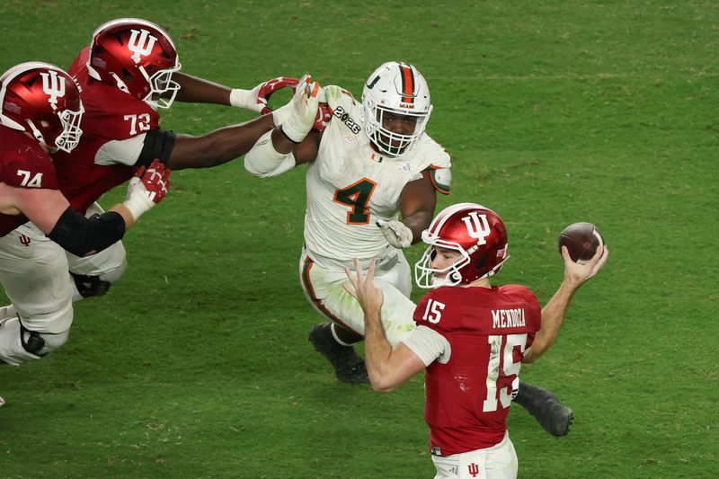 Jan 19, 2026; Miami Gardens, FL, USA; Indiana Hoosiers quarterback Fernando Mendoza (15) passes the ball under pressure by Miami Hurricanes defensive lineman Rueben Bain Jr. (4) in the third quarter during the College Football Playoff National Championship game at Hard Rock Stadium. Mandatory Credit: Kim Klement Neitzel-Imagn Images