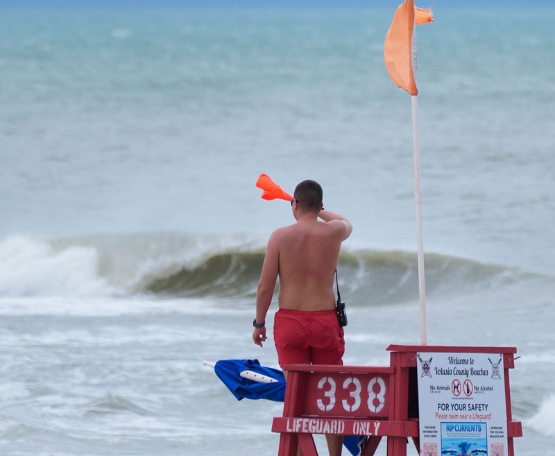 A lifeguard waves beachgoers out of the water as a storm rolls in during Spring Break in Daytona Beach on March 16, 2026.