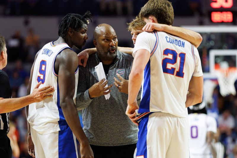 Nov 6, 2025; Gainesville, Florida, USA; Florida Gators associate head coach Carlin Hartman talks with Florida Gators center Rueben Chinyelu (9), Florida Gators forward Thomas Haugh (10) and Florida Gators forward Alex Condon (21) during a timeout against the North Florida Ospreys during the first half at Exactech Arena at the Stephen C. O'Connell Center. Mandatory Credit: Matt Pendleton-Imagn Images