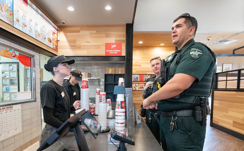 Santa County Sheriff’s Office deputy Matthew Burke, right, places an order with Gracie O’Gara in Jack’s at 6625 Caroline St. in Milton on March 20, 2026. This, the first Jack’s restaurant open in the state of Florida, will be open to the public on Monday, March 23.