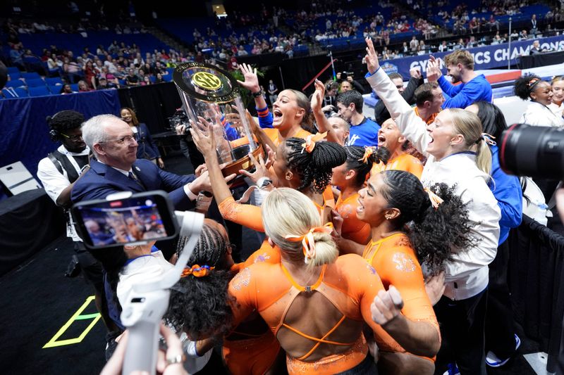 SEC commissioner Greg Sankey hands the championship trophy to the Florida Gators after the SEC Gymnastics Championships at BOK Center in Tulsa, Okla., Saturday, March 21, 2026.