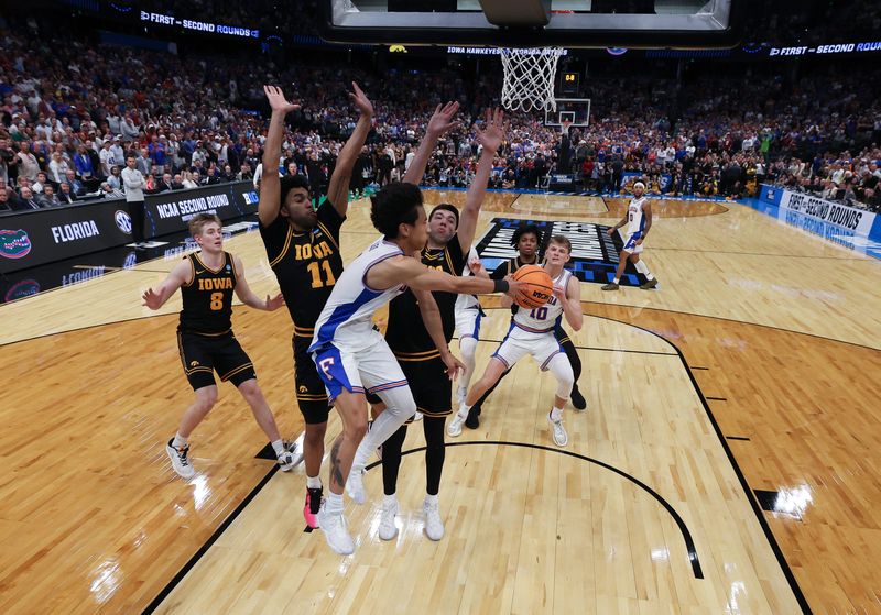 Mar 22, 2026; Tampa, FL, USA; Florida Gators guard Xaivian Lee (1) passes the ball around Iowa Hawkeyes forward Alvaro Folgueiras (7) in the final seconds as Florida Gators was unable to get a shot off in the second half during a second round game of the men's 2026 NCAA Tournament at Benchmark International Arena. Mandatory Credit: Nathan Ray Seebeck-Imagn Images