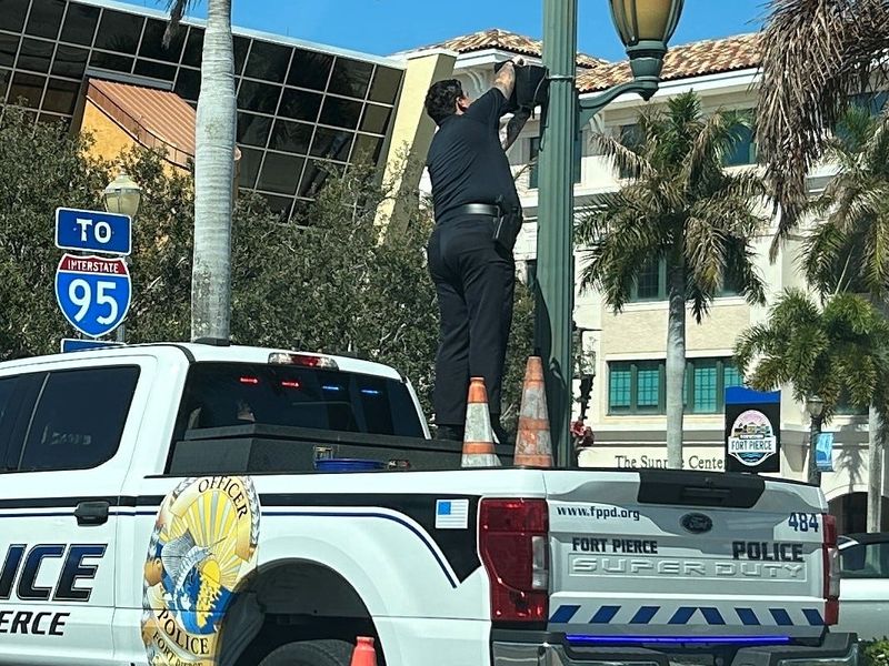 A Fort Pierce police officer works on a Flock camera on U.S. 1 at Orange Avenue in downtown Fort Pierce, Florida, on March 24, 2026.