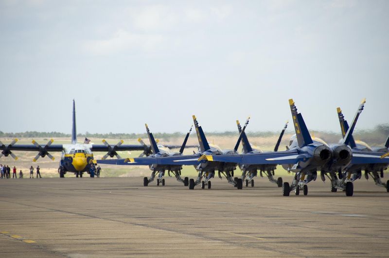 Boeing F/A-18 Hornets assigned to the U.S. Navy flight demonstration squadron, the Blue Angels, taxi past Fat Albert, a C-130 Hercules, at Naval Air Station Meridian on March 24, 2011.