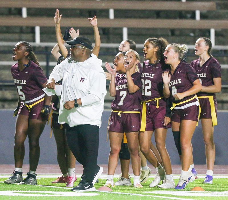 Niceville head coach Adron Robinson and players cheer after an extra point during the Niceville Choctaw flag football game at Niceville.The Lady Eagles won 20-12, and remain undefeated.