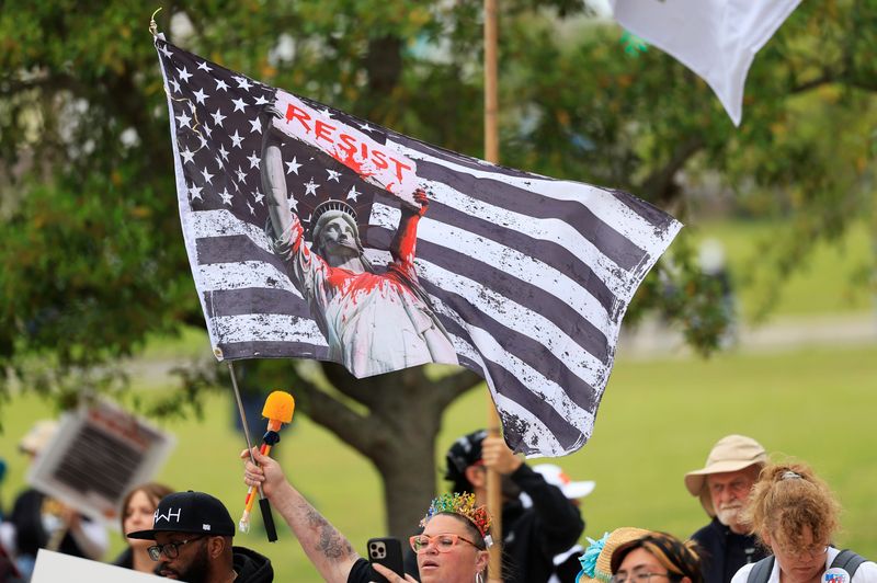 A protester holds a flag during the third No Kings Protest, Saturday, March 28, 2026, in downtown Jacksonville, Fla. A few thousand marched in solidarity, beginning at Friendship Fountain and ending with a rally at the Duval County Courthouse, against Trump and his administration.