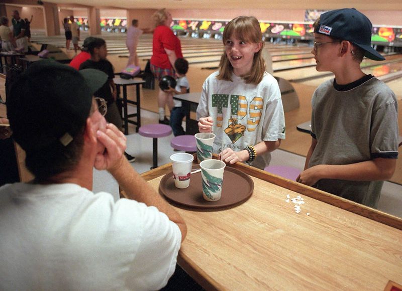 Scott Montgomery, left, spends Tuesday with his daughter, Kendyl, 12, and son, Robert, 10, at Sarasota Lanes in September, 1999.