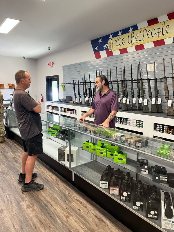 Assistant Manager Joseph Pyritz assists a potential customer at Santa Rosa Outfitters near Milton.