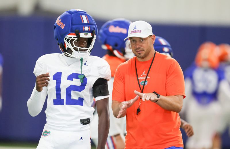 Florida head coach Jon Sumrall talks with Florida cornerback Ben Hanks II (12) during practice during spring practice at Sanders Practice Fields in Gainesville, FL on Thursday, April 2, 2026. [Alan Youngblood/Gainesville Sun]