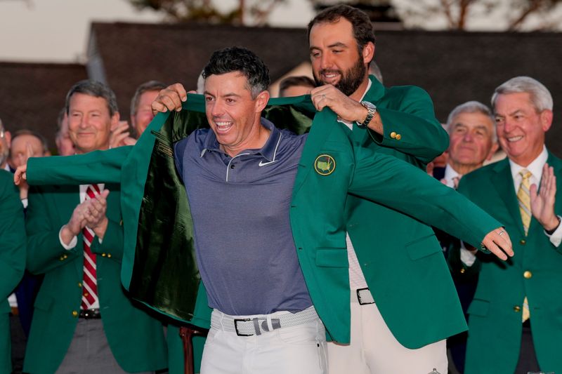 Apr 13, 2025; Augusta, Georgia, USA; Scottie Scheffler places the green jacket on Rory McIlroy during the green jacket ceremony during the final round of the Masters Tournament at Augusta National Golf Club. Mandatory Credit: Kyle Terada-Imagn Images