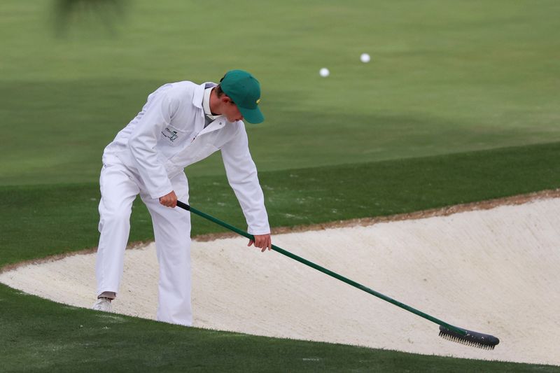 Apr 7, 2026; Augusta, Georgia, USA; A course worker rakes a bunker at the practice facility during a practice round for the Masters Tournament at Augusta National Golf Club. Mandatory Credit: Bill Streicher-Imagn Images