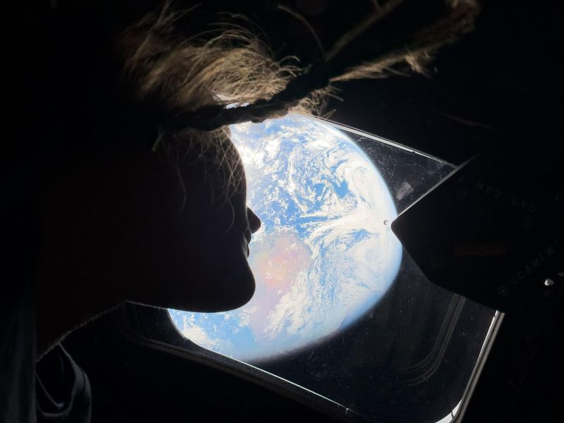 NASA astronaut Christina Koch, a mission specialist on Artemis II, gazes out the windows of the Orion vehicle back at Earth as she and the crew head toward the moon. Koch, who already holds several NASA records from her first spaceflight in 2019 to the International Space Station, became the first woman to fly on a lunar mission.