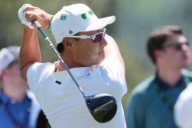 Apr 11, 2026; Augusta, Georgia, USA; Haotong Li tees off on the first hole during the third round of the Masters Tournament at Augusta National Golf Club. Mandatory Credit: Michael Madrid-Imagn Images