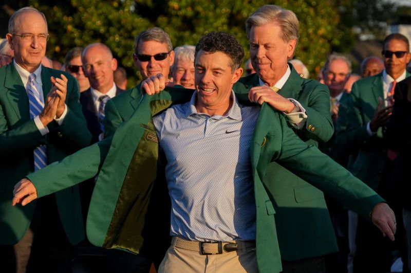 Apr 12, 2026; Augusta, Georgia, USA; Augusta National Golf Club chairman Fred Ridley places the green jacket on Rory McIlroy during the green jacket ceremony after the final round of the Masters Tournament at Augusta National Golf Club. Mandatory Credit: Michael Madrid-Imagn Images