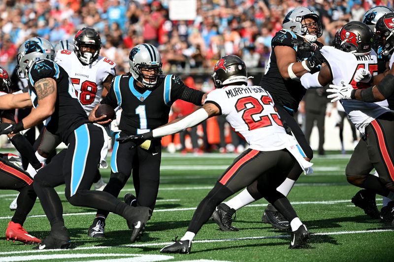 Dec 26, 2021; Charlotte, North Carolina, USA; Carolina Panthers quarterback Cam Newton (1) with the ball as Tampa Bay Buccaneers cornerback Sean Murphy-Bunting (23) defends in the second quarter at Bank of America Stadium. Mandatory Credit: Bob Donnan-USA TODAY Sports