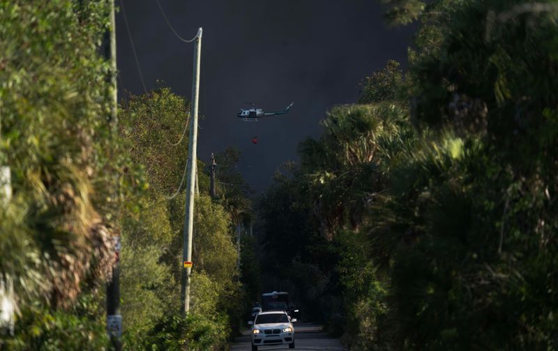 A Division of Forestry helicopter fights a brush fire in the Picayune Strand area in Collier County on Monday, April 13, 2026.