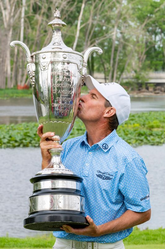 May 29, 2022; Benton Harbor, Michigan, USA; Steven Alker kisses the trophy on the eighteenth green after winning the 2022 KitchenAid Senior PGA Championship at Harbor Shores. Mandatory Credit: Raj Mehta-USA TODAY Sports