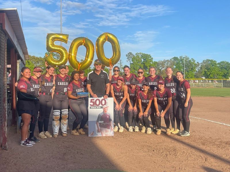 Niceville head softball coach Danny Hensley and his players celebrate his 500th career win before the Eagles' 4-3 win over Greenwood.