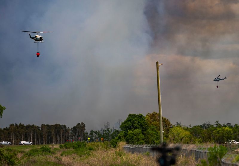 Collier County Sheriff Fire Rescue and Forestry helicopters along with other fire response teams from other agencies work near the Seven Shores Community and swamp buggy race track in Naples, Fla., as they battle the 1,500-acre Picayune Strand brush fire on Tuesday, April 14, 2026.