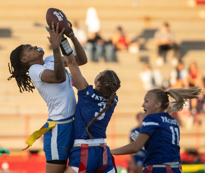 Washington and Pace flag football players collide near midfield during a Wildcat passing attempt during the open quarter of a flag football matchup on April 14, 2026.