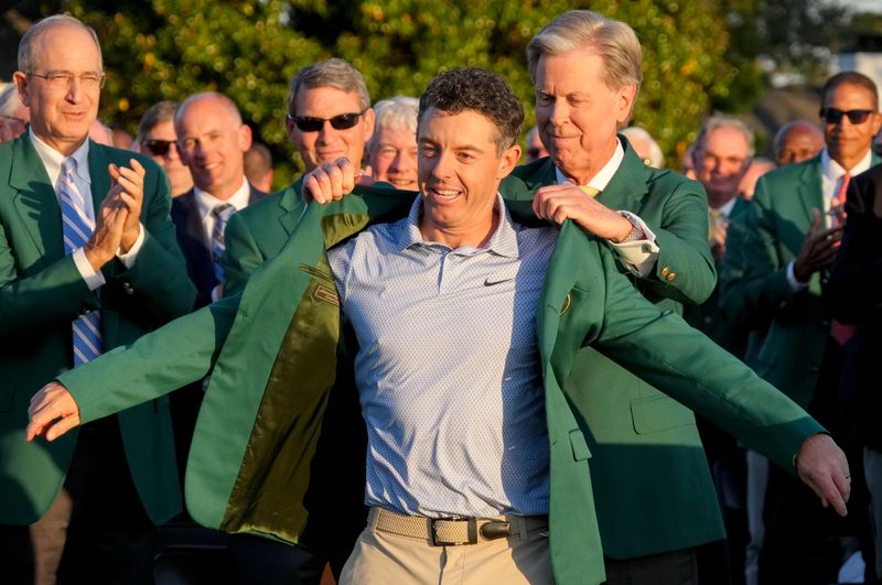 Augusta National Golf Club chairman Fred Ridley places the green jacket on Rory McIlroy during the green jacket ceremony after the final round of the Masters Tournament at Augusta National Golf Club on April 12, 2026.