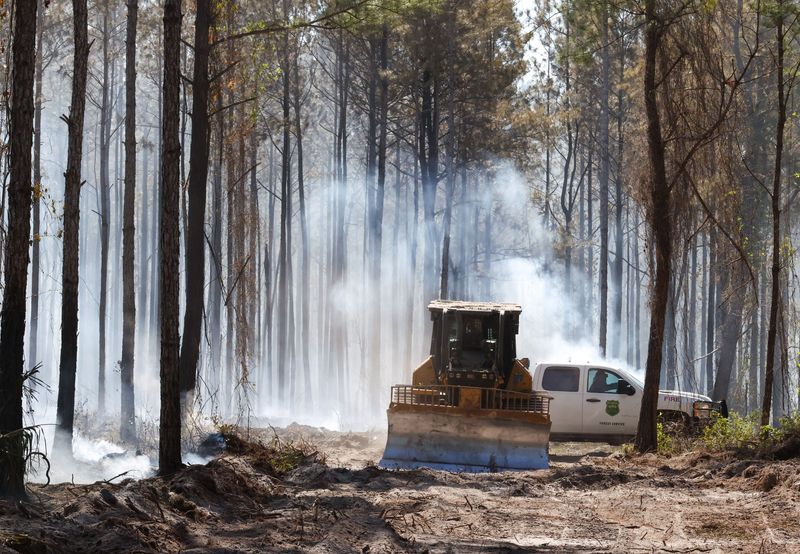 A heavy bulldozer refuels on April 16 as the Florida Forest Service cuts firebreaks on a 400-acre wildfire that started April 15 in the Balu Forest in Gainesville.