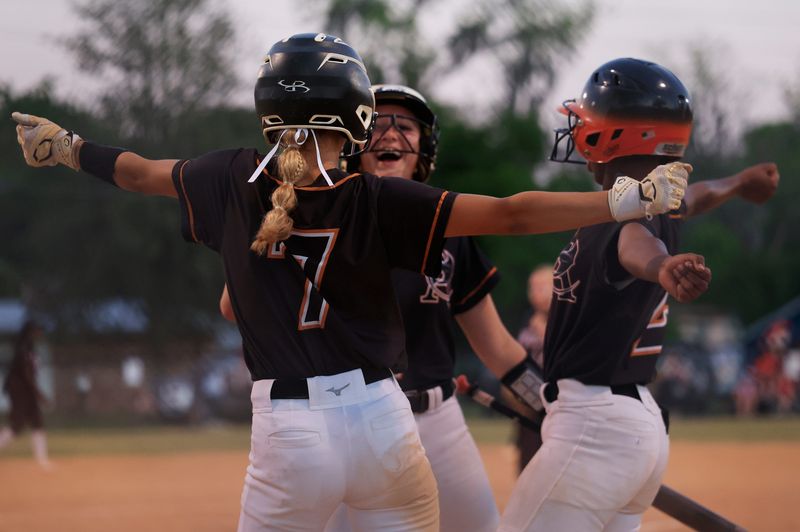 From left, Atlantic Coast's Stella Lynton (7) dances after scoring with Lily Maguire (42) and Skye Deans (2) during the eighth inning of a Gateway Conference softball final at Baldwin Middle-Senior High School, Thursday, April 16, 2026, in Baldwin, Fla. The Atlantic Coast Stingrays blanked the Baldwin Indians 11-0, all scored in the 8th inning, for the Gateway Conference title.