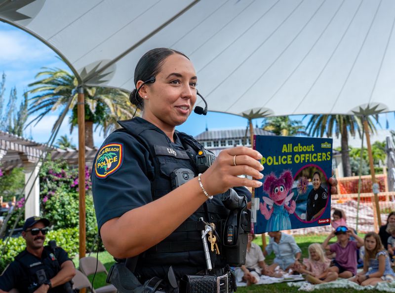 Palm Beach police officer Frances Caro reads the book "All About Police Officers," By Mari Schuh to children during the Preschool Story Time Police Day event at the Society of the Four Arts on April 16.