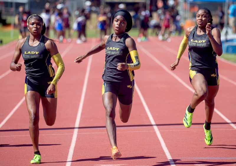 Winter Haven senior Desirae Murray, center, beats teamates Ashari Conoly, left, and Mar'Kaila Holloway in the 100 meters on Thursday at the Class 4A, District 6 track and field meet at George Jenkins High School.