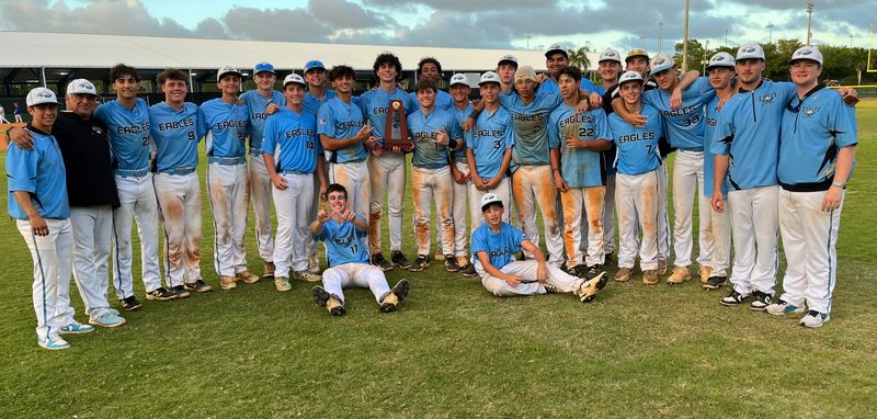 St. John Paul players and coaches celebrate with the District 13-2A championship trophy on April 17 in Boca Raton.