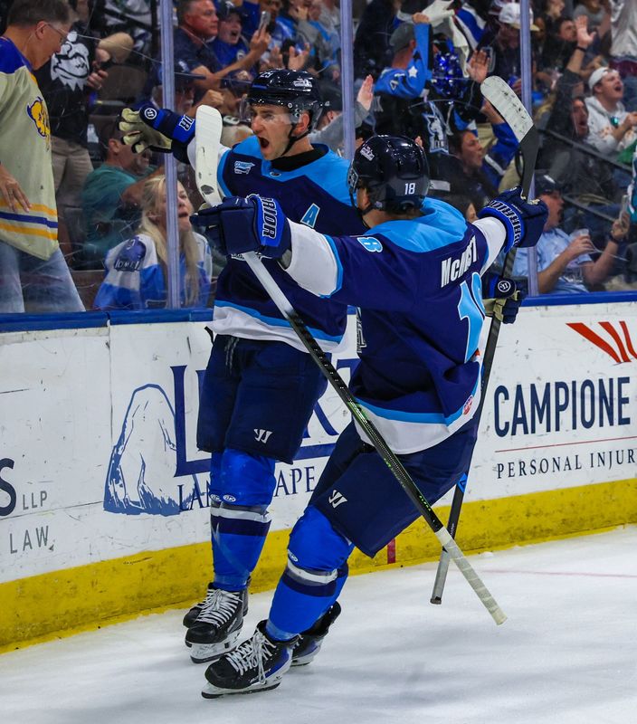 Jacksonville Icemen forward Craig Martin (29), left, celebrates his second goal of a hat trick with forward Adam McMaster (18) against the Orlando Solar Bears in Sunday's hockey game.