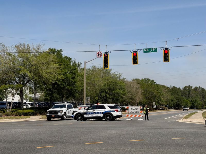 Gainesville Police Department officers stand watch as North Main Street at Northeast 39th Avenue is shut down April 20, 2026, because of a nearby wildfire.